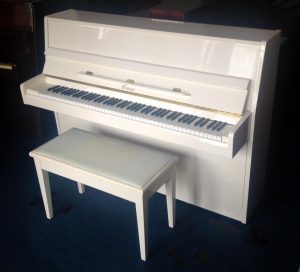 white upright piano and stool