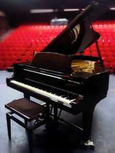 steinway grand piano in auditorium red seats